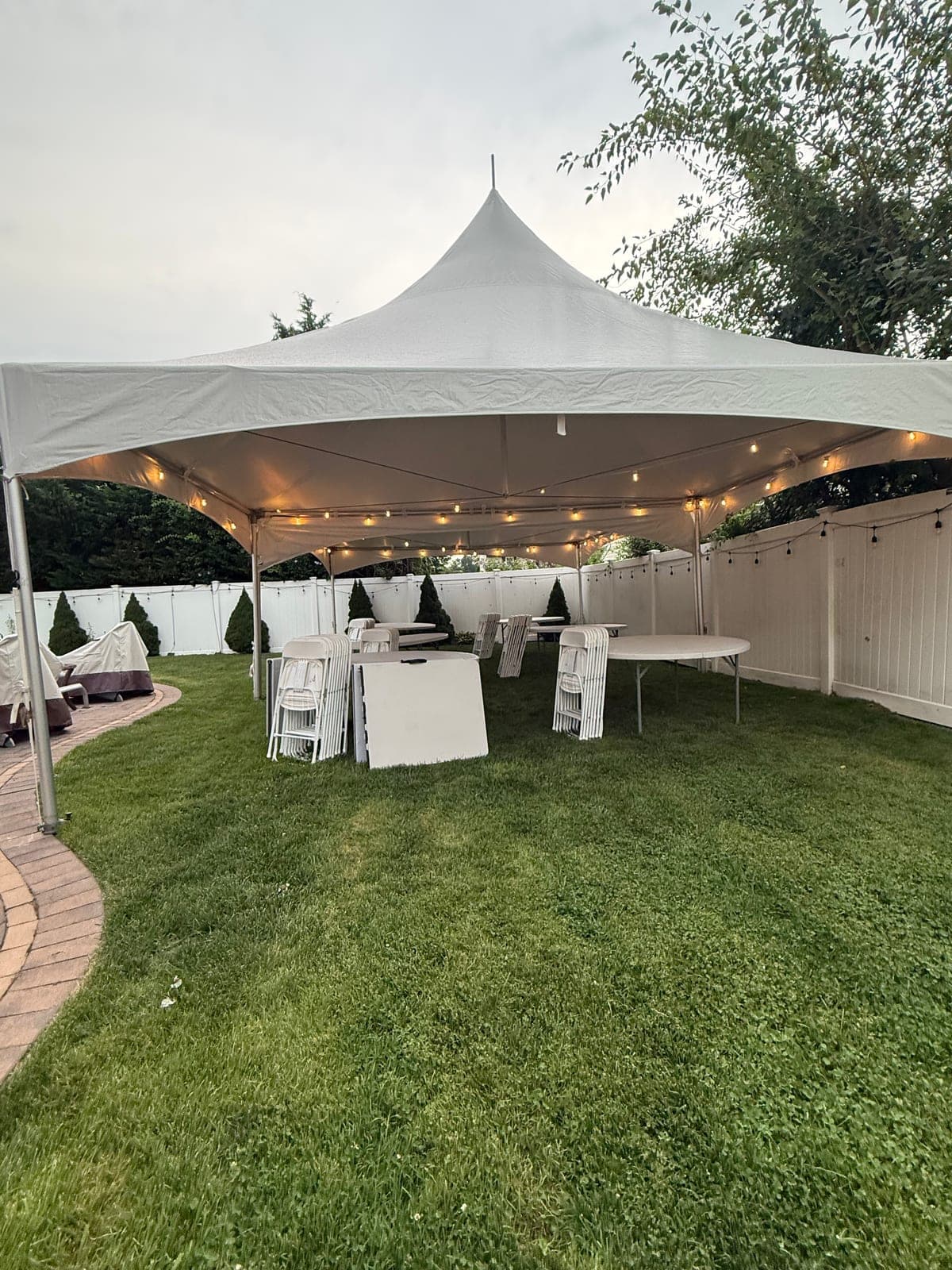 20 by 35 high-peak tent: 20×35 on the lawn, string lights strung