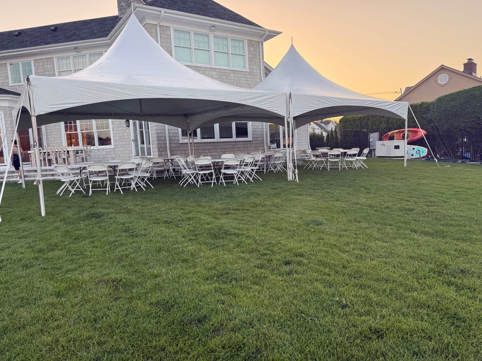 20 by 40 high-peak tent: 20×40 at sunset, tables and chairs set